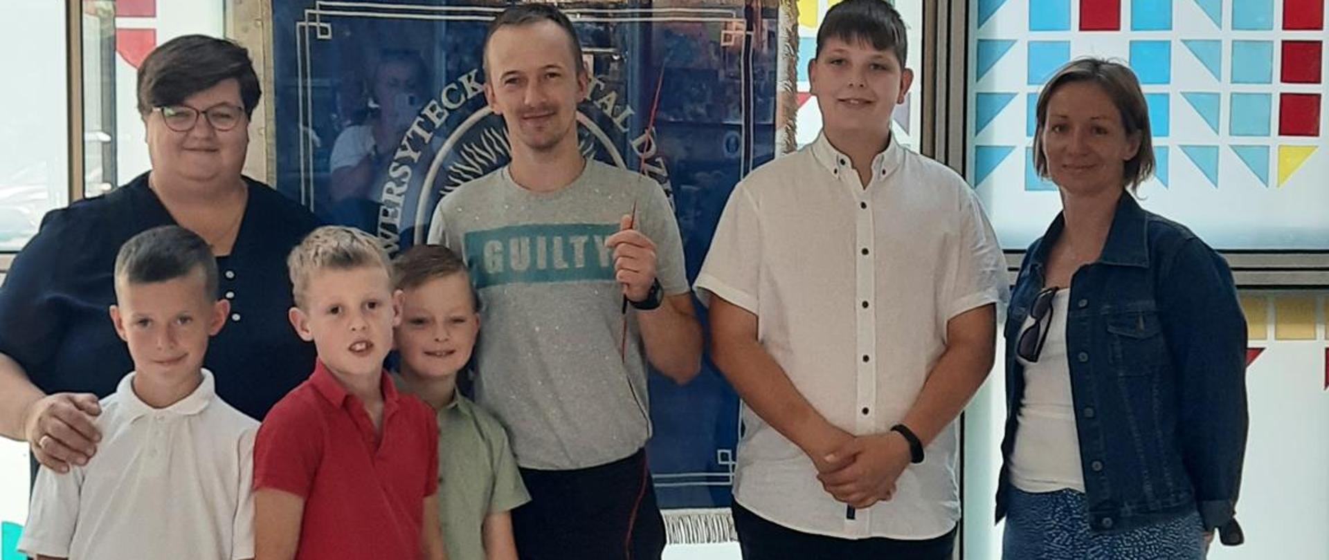 zdjęcie przedstawia wspólne zdjęcie przedstawicieli akcji z tata Gabrysi oraz przekazanym dla niej prezentem.