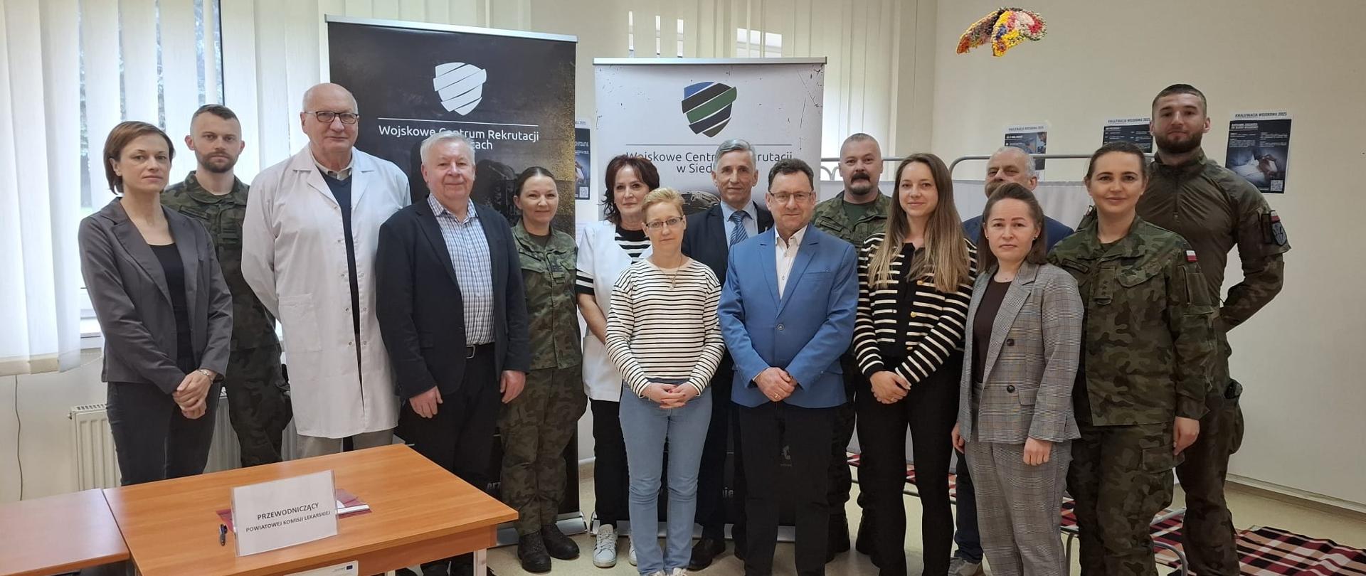 Zdjęcie grupowe przedstawiające członków Powiatowej Komisji Kwalifikacyjnej wraz ze starostą sokołowskim. Na zdjęciu między innym pracownicy Starostwa Powiatowego, żołnierze i personel medyczny.