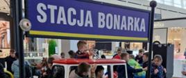Duży niebieski napis Stacja Bonarka.