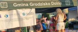 zielony namiot pod którym tłoczą się ludzie, piękna słoneczna pogoda 