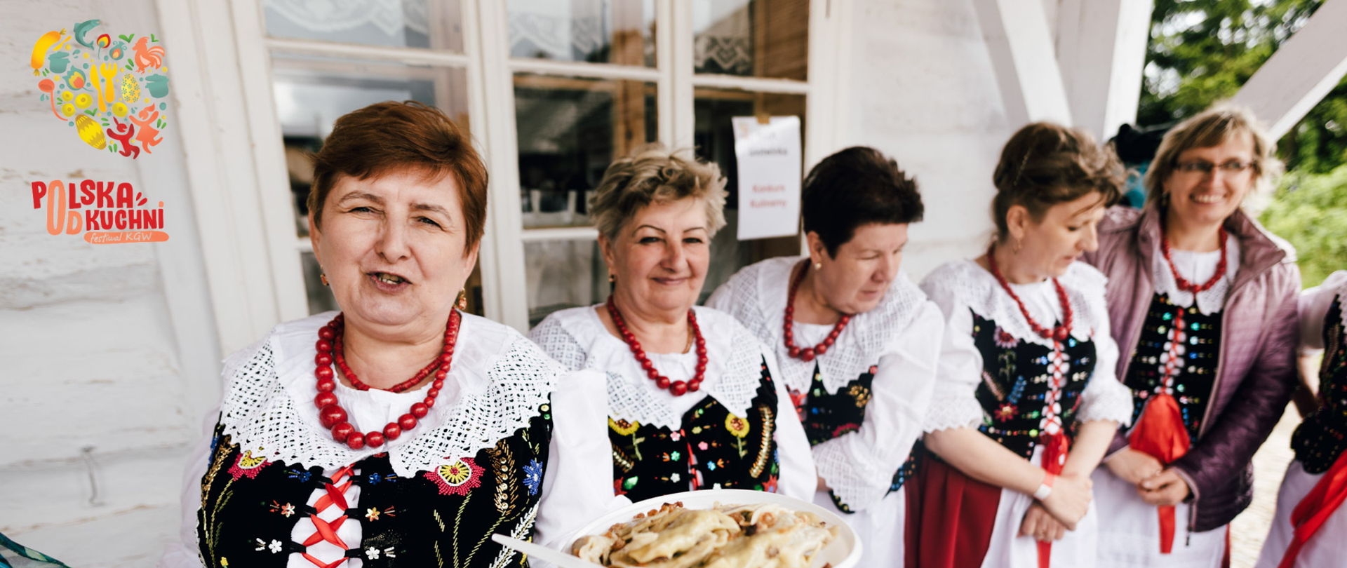 kilka osób w kolorowych ubraniach na zewnątrz pokazujących domowe jedzenie