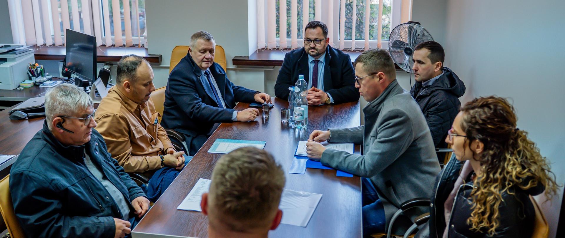 Odbiór końcowy prac, czestnicy spotkania zgromadzeni przy stole, u szczytu stołu siedzi Starosta Gorlicki Mirosław Waląg