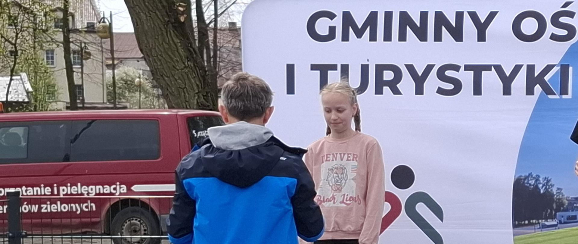 Zosia odbiera medal za II miejsce w rzucie piłeczką palantową