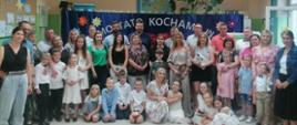Grupa dorosłych i dzieci stojących obok siebie i kucających