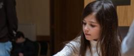 Młoda uczestniczka w skupieniu rozgrywa partię szachów