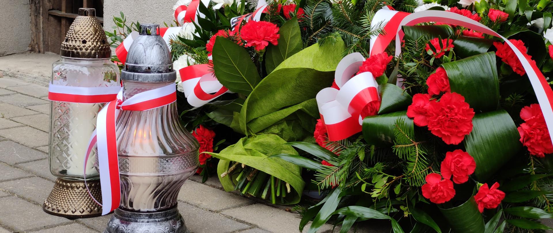 Kwiaty i znicze pod tablicą upamiętniającą ofiary Powiatowego Urzędu Bezpieczeństwa Publicznego w Jaśle