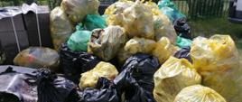 Kilkanaście zółtych i czarnych worków plastikowych leżących w nieładzie