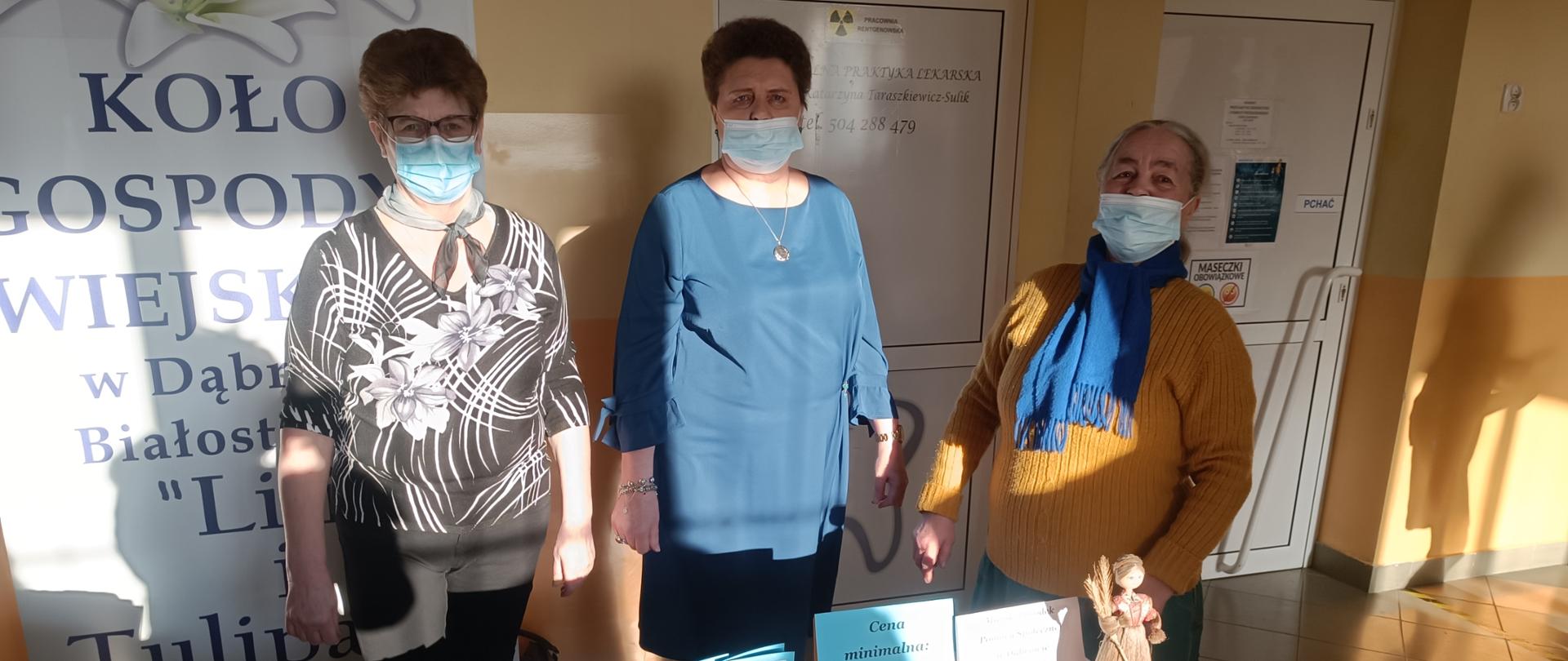 Panie sprzedające na kiermaszu podczas koncertu wykonane przez Klub Seniora pocztówki