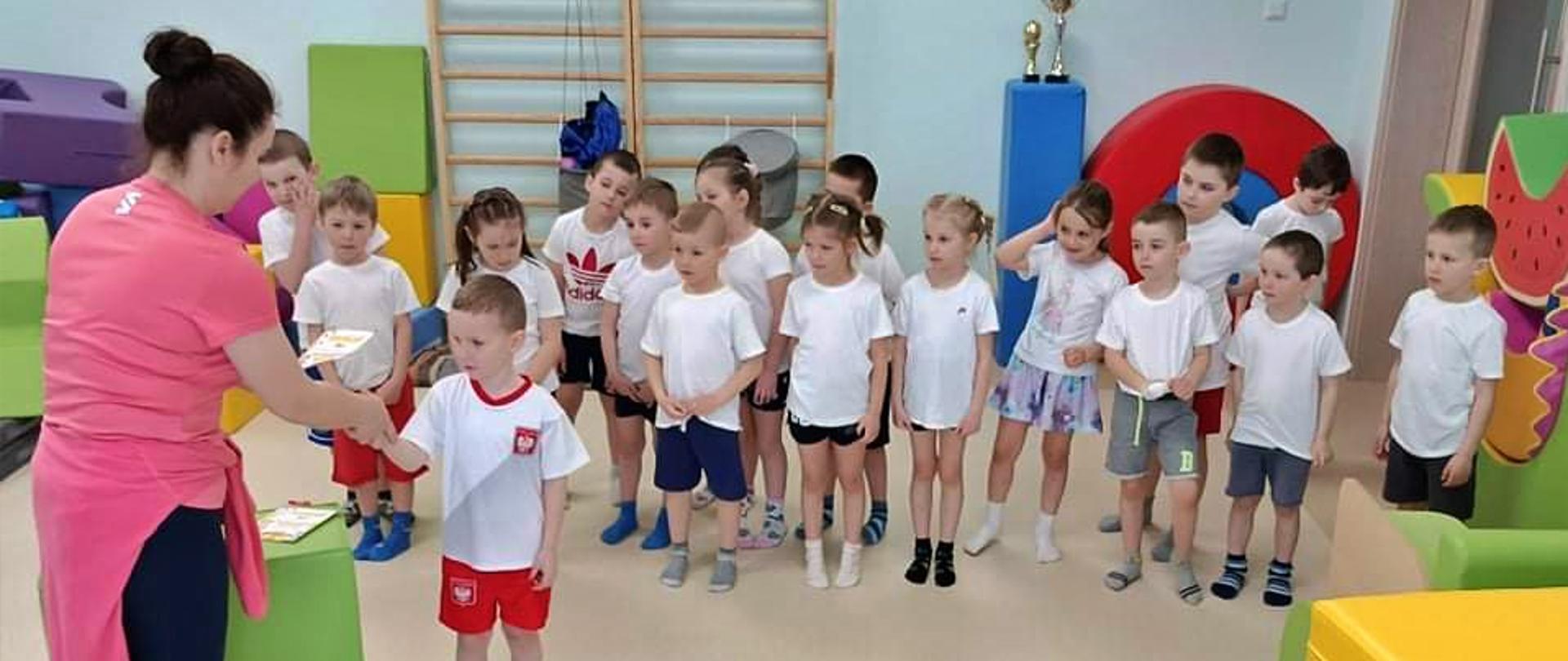 Przedszkolaki podczas ćwiczeń i zabaw sportowych zorganizowanych w ramach dnia sportu