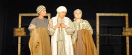 trzy kobiety w pasiastych sukienkach stoją na scenie 
