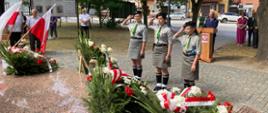 harcerze salutują pod pomnikiem