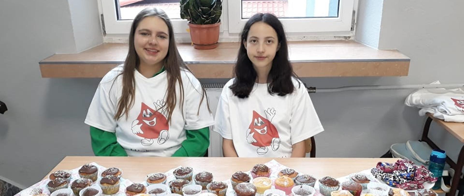 Wolontariuszki Iskierki Nadziei na tle przygotowanych mufinek dla honorowych dawców krwi.
