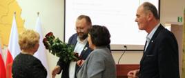 Na fotografii uwieczniono moment, w którym przewodniczący Rady Powiatu, Starosta Sokołowski oraz Wicestarosta składają osobiste podziękowania dotychczasowej dyrektor Powiatowego Urzędu Pracy w Sokołowie Podlaskim, przekazując na ręce Pani Dyrektor symboliczny bukiet róż.