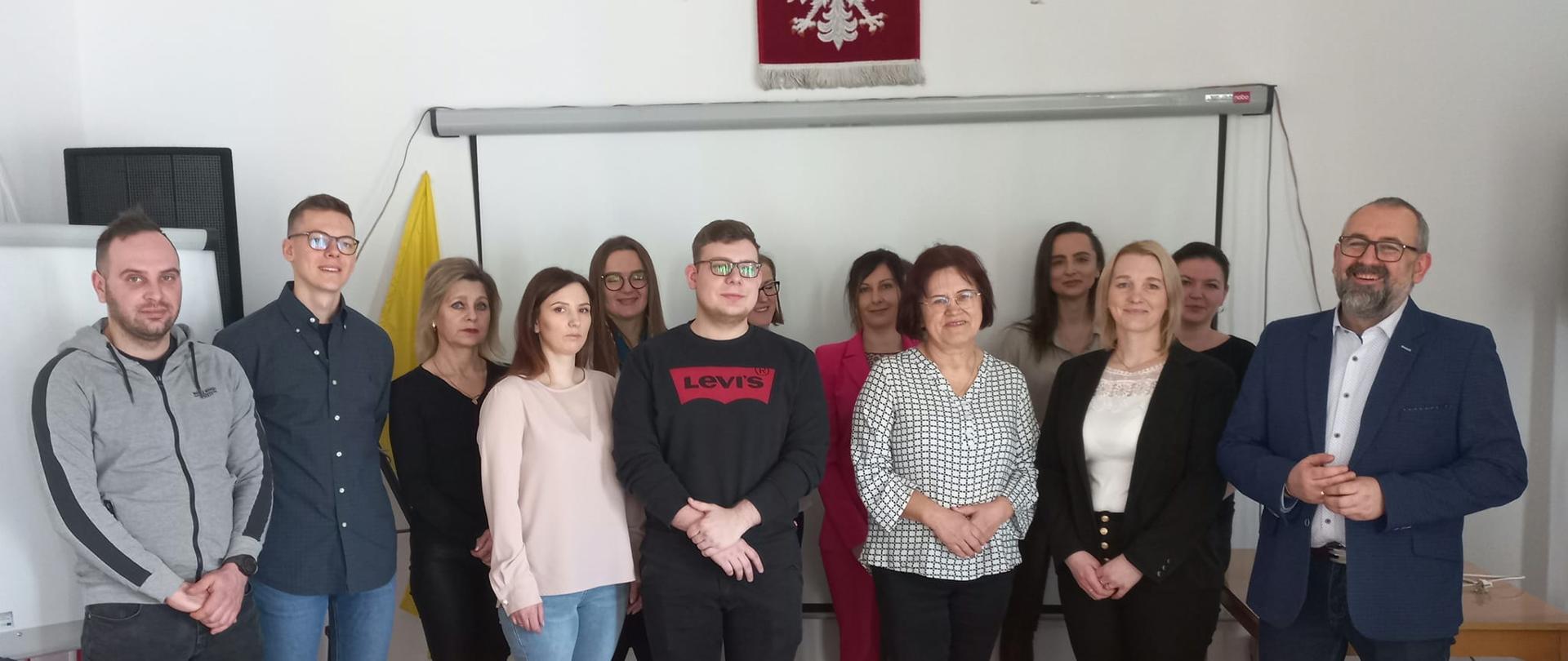 Zdjęcie grupowe beneficjentów dotacji na rozpoczęcie działalności, pracowników Powiatowego Urzędu Pracy oraz Starosty Przasnyskiego.