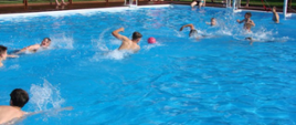 Uczestnicy zawodów w basenie biorą udział w konkurencjach sportowych