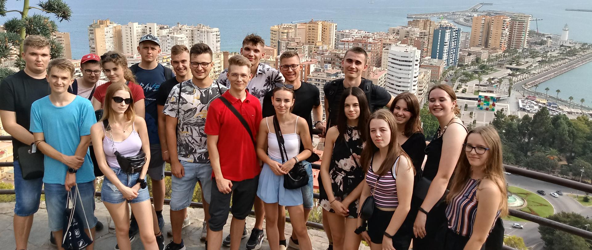 Grupa młodych kobiet i mężczyzn na tle miasta Malaga