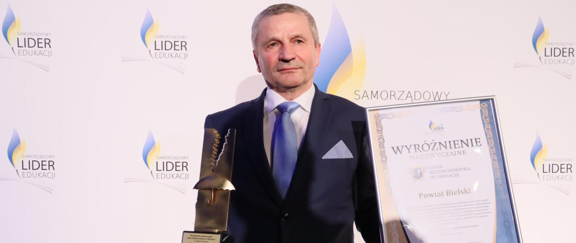 Naczelnik Wydziału Oświaty, Kultury i Ochrony Zdrowia Anatol Grzegorz Tymiński z certyfikatem i statuetką