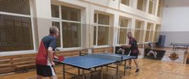 Akcja meczowa - dwóch mężczyzn przy stole tenisowym