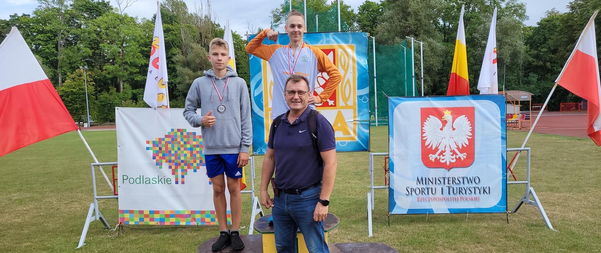 Młodzi zawodnicy na podium pozują z trenerem