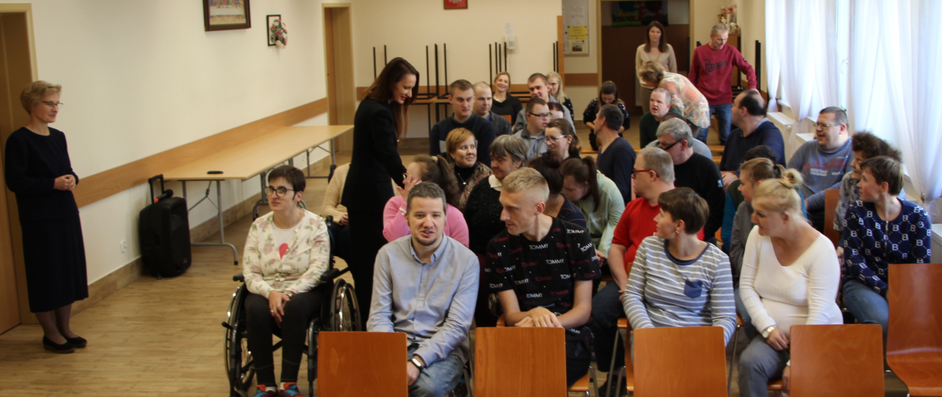 zdjęcie starosty, który wita się z podopiecznymi placówki, w tle stoi siostra oraz pracownica