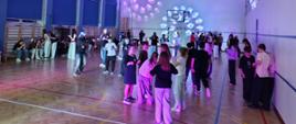 Uczniowie klas IV - VIII bawią się w rytm muzyki na sali gimnastycznej podczas dyskoteki karnawałowej