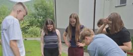 Uczniowie klasy ósmej zasadzają drzewko przed szkołą