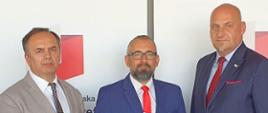 Zdjęcie przedstawia Starostę Przasnyskiego Krzysztof Bieńkowski z przedstawicielami Zarządu Warmińsko-Mazurskiej Specjalnej Strefy Ekonomicznej w Olsztynie. Na zdjęciu starosta prezentuje dokument z opracowaniem poświęconym terenom inwestycyjnym Przasnyskiej Strefy Gospodarczej.