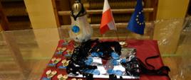 Stół dekoracyjny - medale, puchary, znicz i flagi - polska i unijna