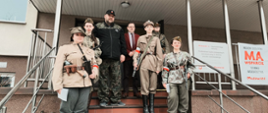 Uczniowie wraz z nauczycielem oraz starostą pozują do zdjęcia na schodach przed siedzibą Starostwa Powiatowego w Sokołowie Podlaskim