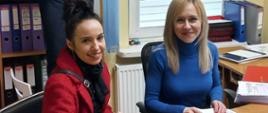 Nagrania - nad siedzącymi przed biurkiem kobietami stoi operator kamery