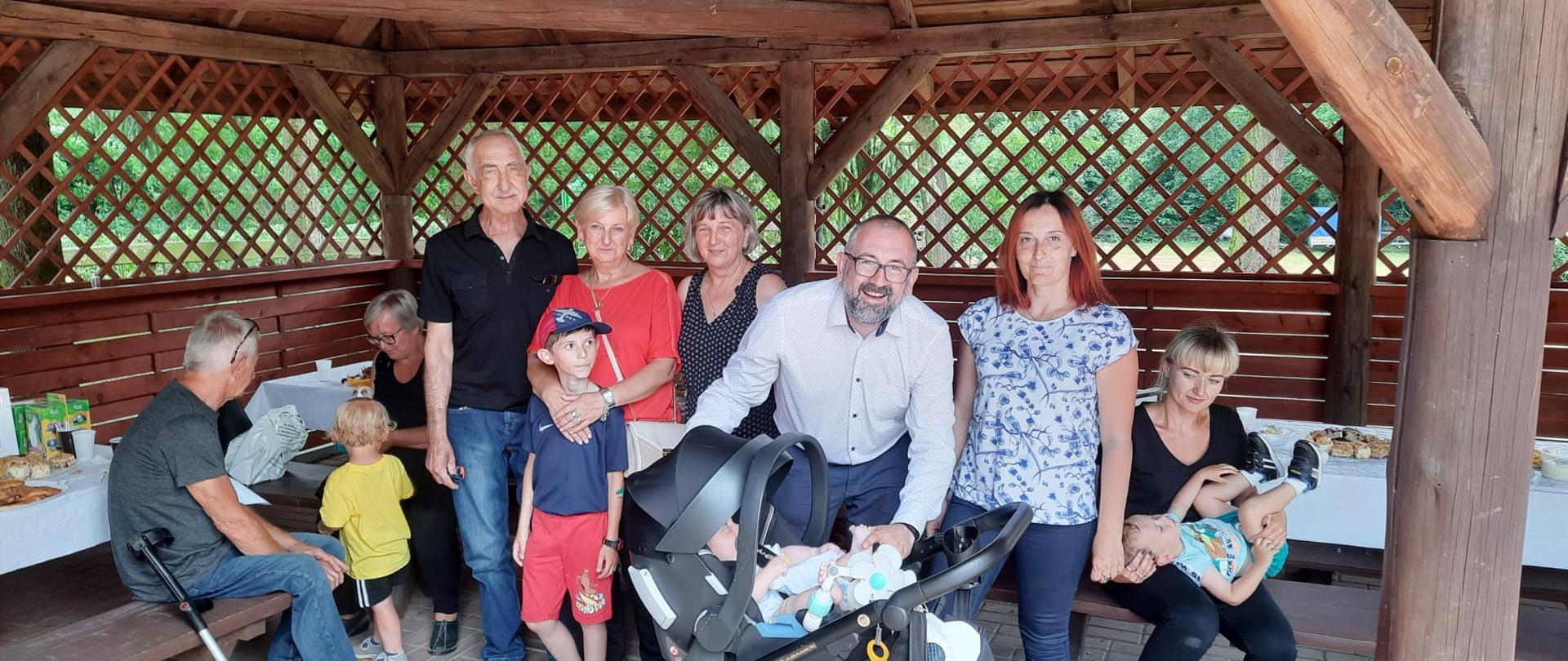 Zdjęcie przedstawia pozujących do zdjęcia Starostę Przasnyskiego Krzysztofa Bieńkowskiego oraz uczestników Dnia Dziecka zorganizowanego w nadleśnictwie Przejmy przez Powiatowe Centrum Pomocy Rodzinie.