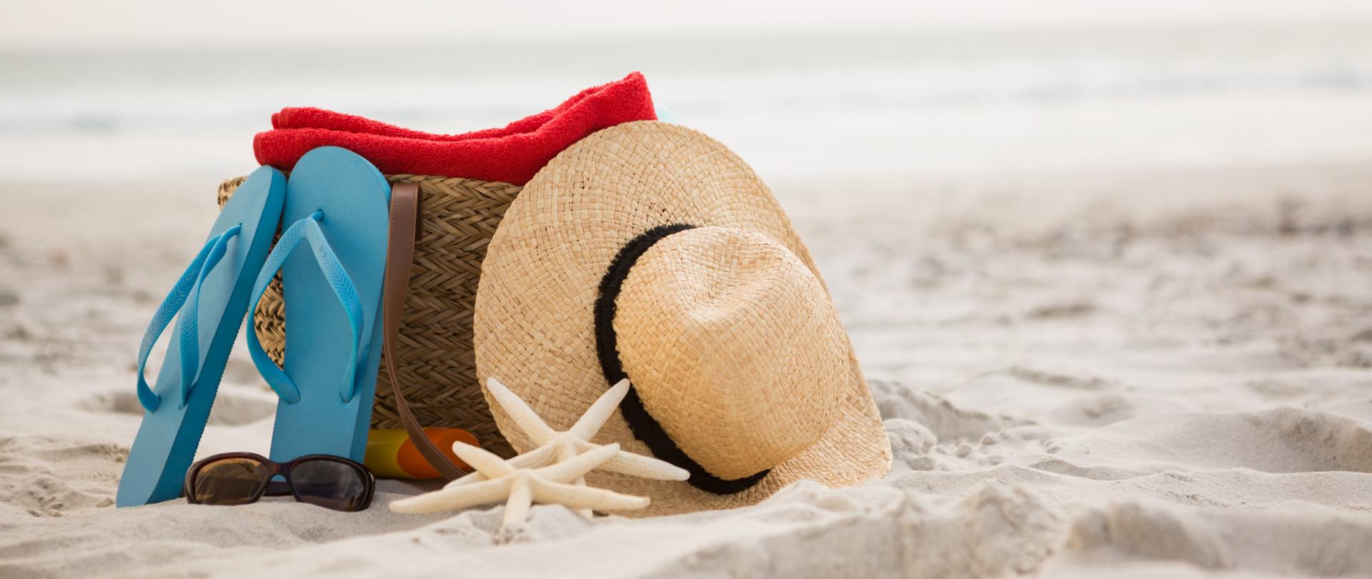 Bag and beach accessories kept on sand at beach
