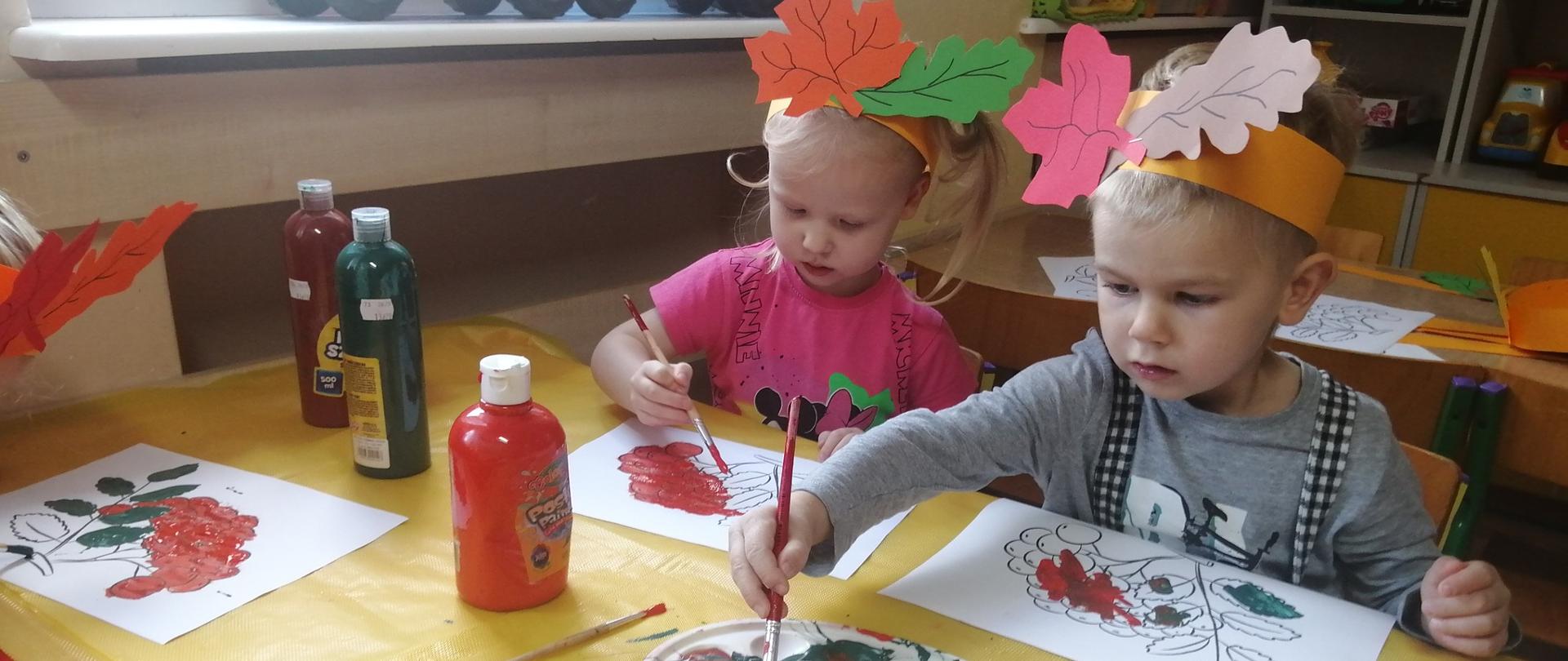 Dzieci malują farbami rysunek z jarzębiną 