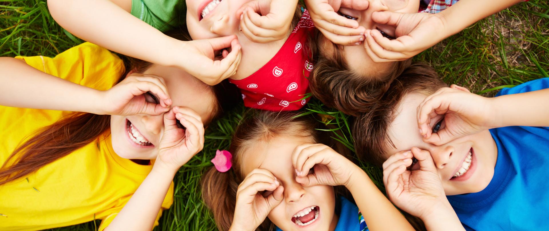 Group of cute children lying on grass 