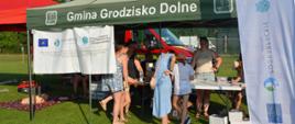 zielony namiot pod którym tłoczą się ludzie, piękna słoneczna pogoda 