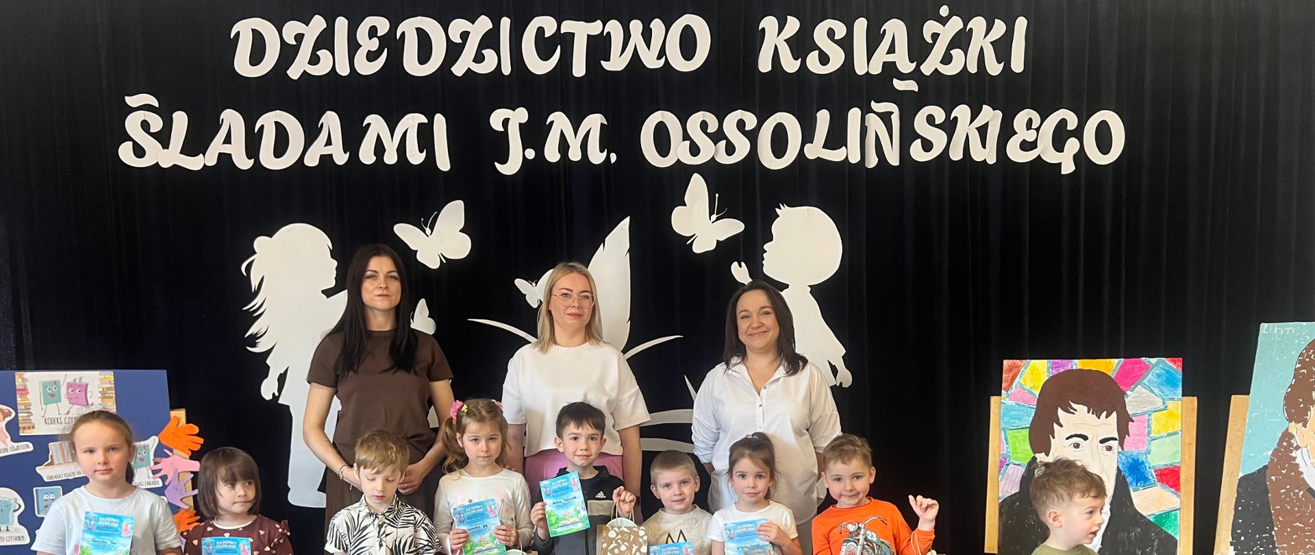 Dzieci biorące udział w konkursie plastycznym „Magia ukryta pomiędzy stronami” pozują do pamiątkowego zdjęcia wraz z wychowawczyniami.