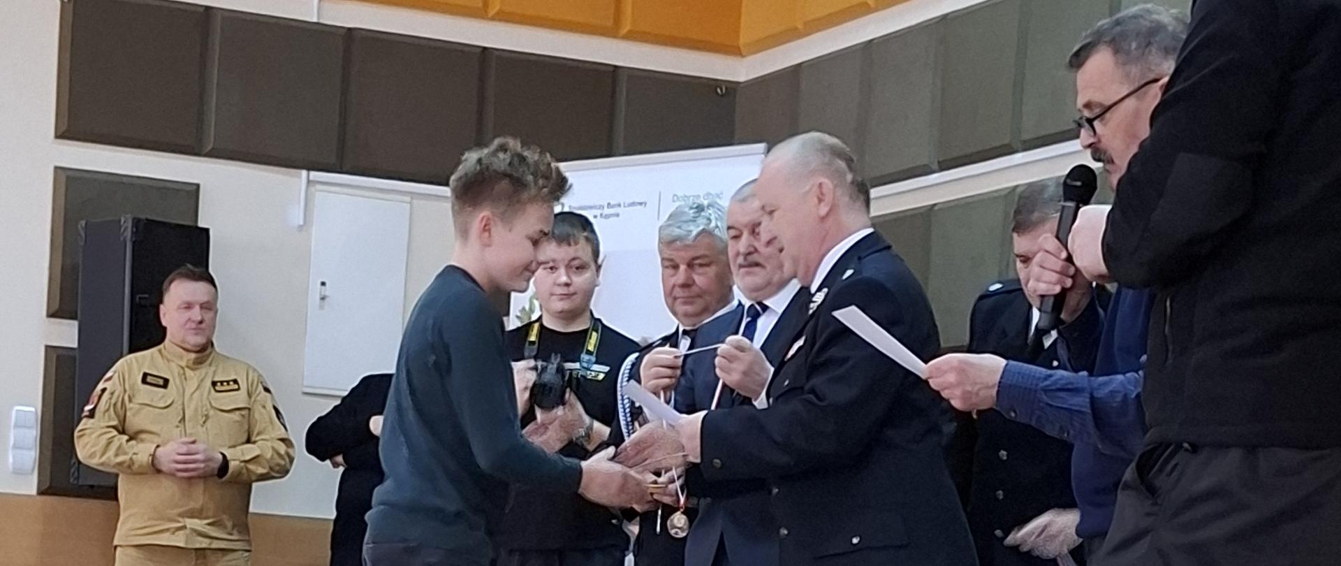 Tomek odbiera medal i dyplom za udział w turnieju