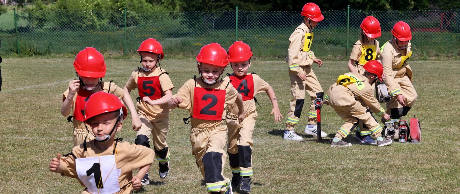 strażacy ochotniczych straży pożarnych podczas wykonywania ćwiczeń bojowych na zawodach strażackich