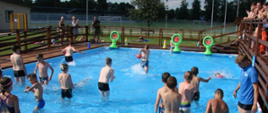 Uczestnicy zawodów w basenie biorą udział w konkurencjach sportowych