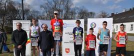 Grześ Bura na podium w towarzystwie innych sportowców 