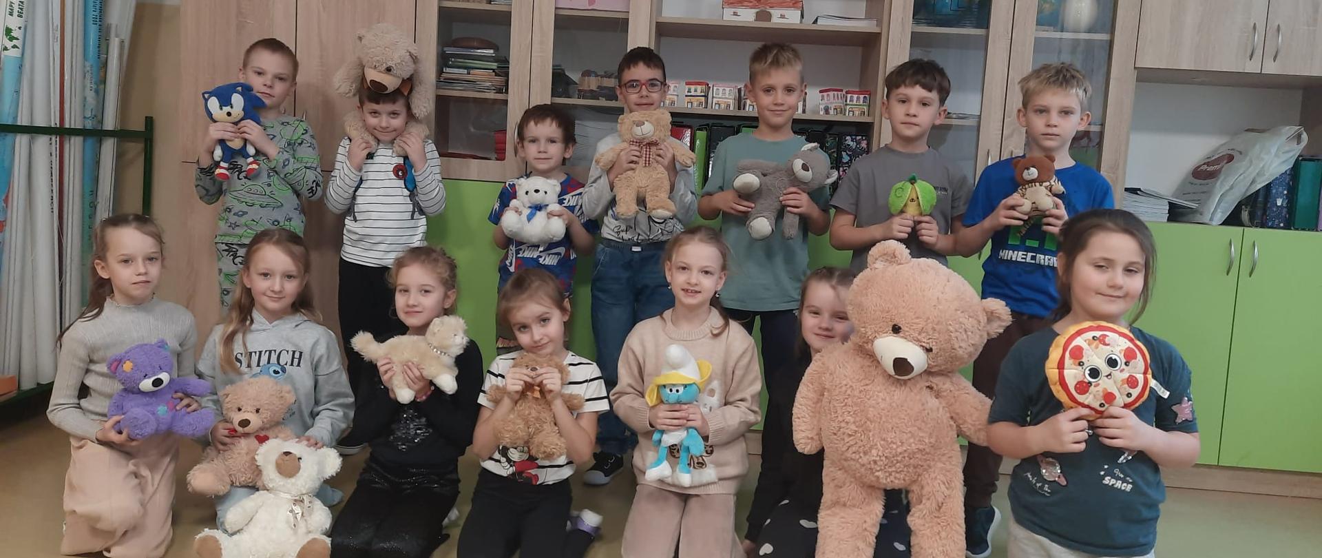 Uczniowie klasy 1 A pozują do zdjęcia ze swoimi pluszakami.