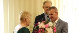 od lewej Skarbnik Powiatu, Wicestarosta Zambrowski wręcza kwiaty oraz Starosta Zambrowski