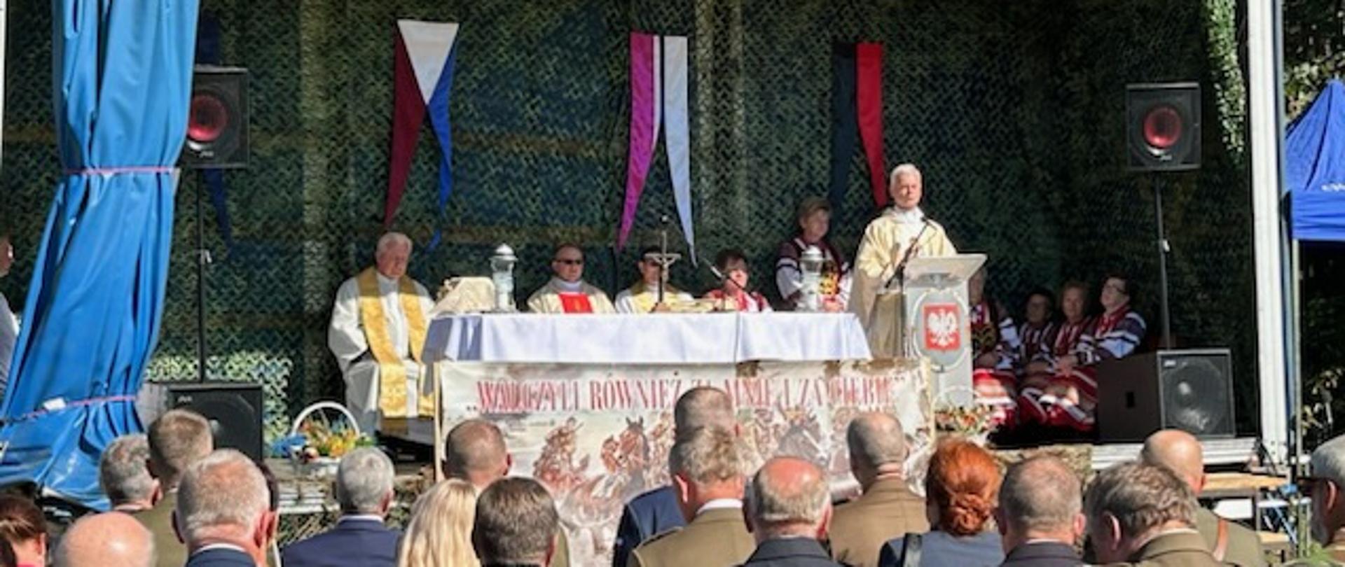 Księża w złotych ornatach sprawują mszę świętą w intencji poległych
