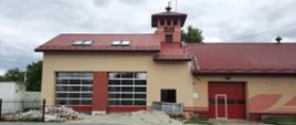 beżowo czerwony budynek remizy z dwiema dużymi bramami wjazdowymi,