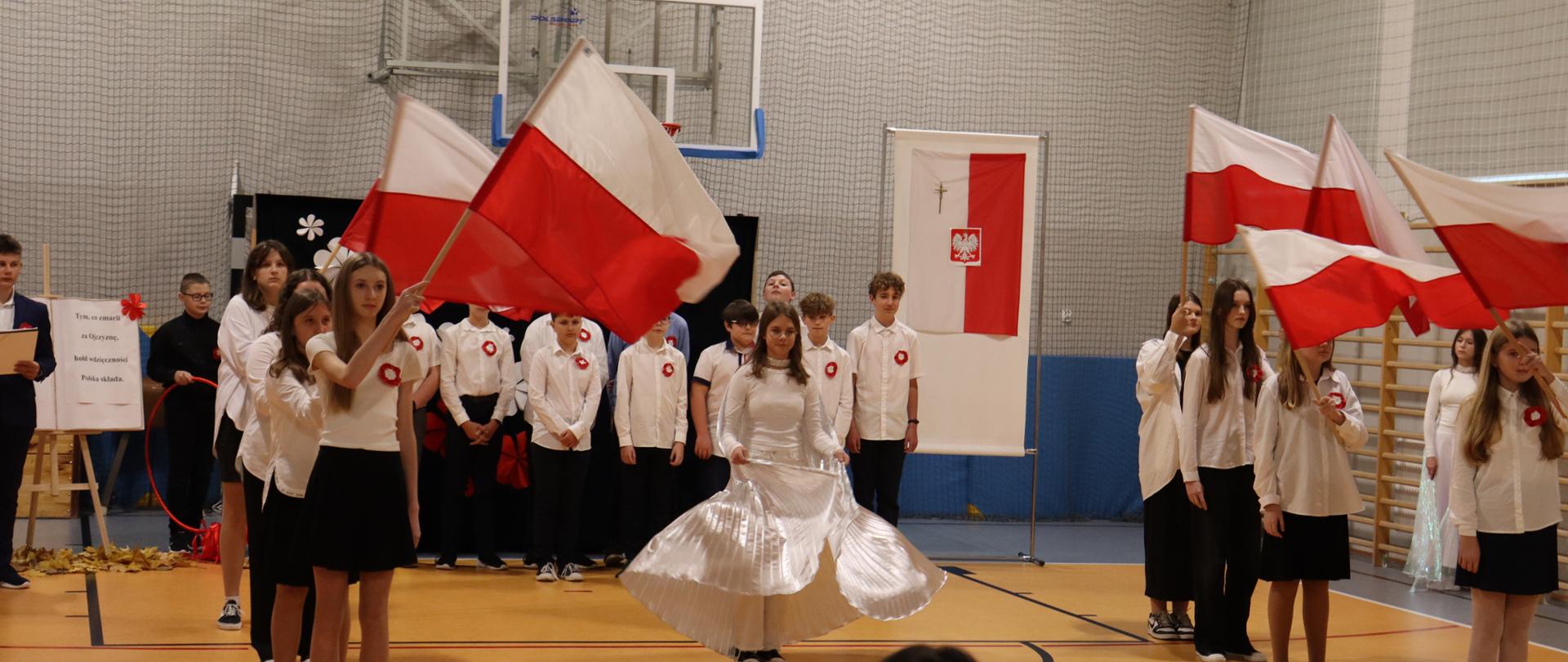 uczennice tańczą z biało czerwonymi flagami