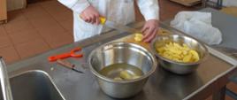 Uczeń podczas przygotowywania posiłku - kroi ziemniaki