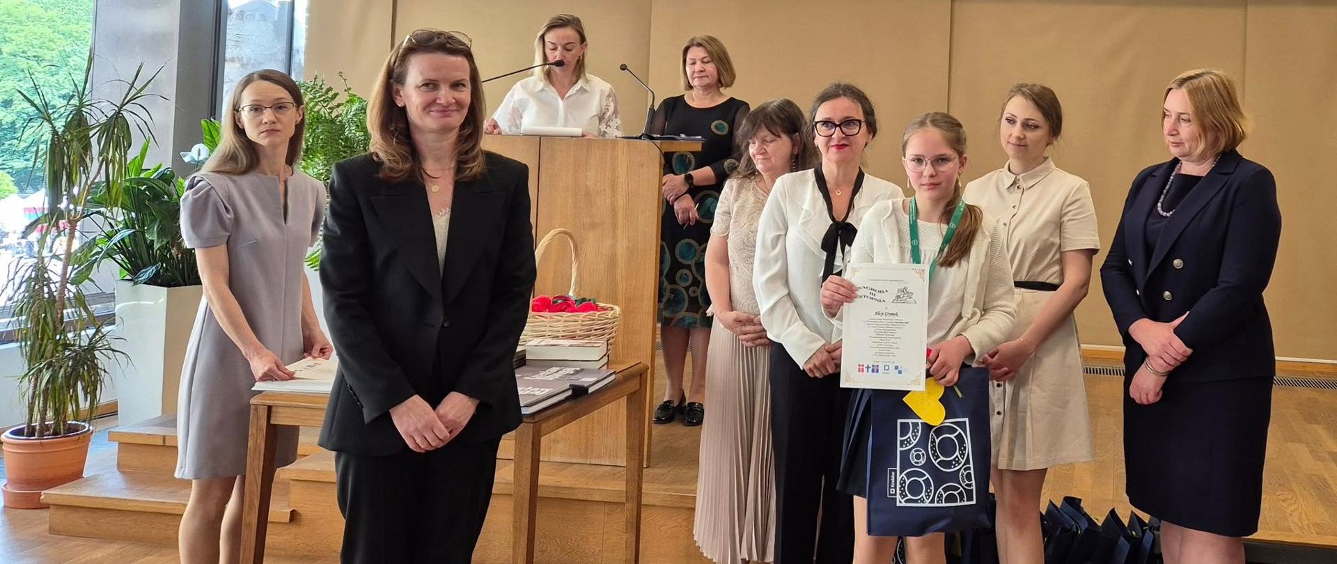 Uczennica otrzymuje nagrodę w konkursie.