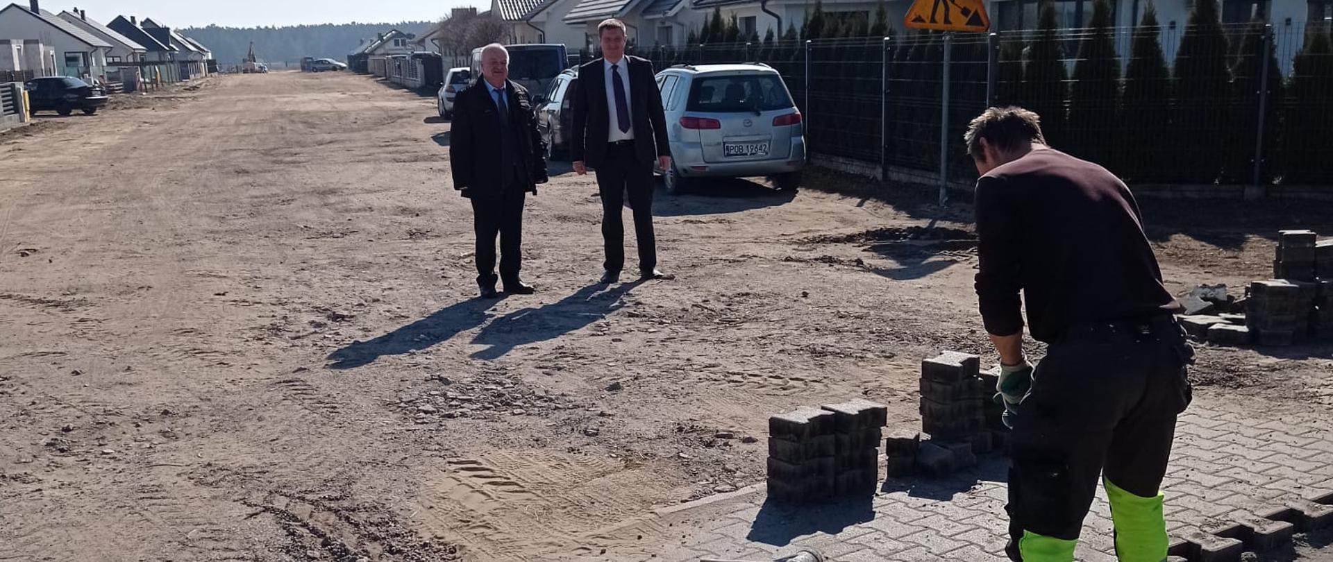 Dwóch mężczyzn stoi na placu budowy drogi