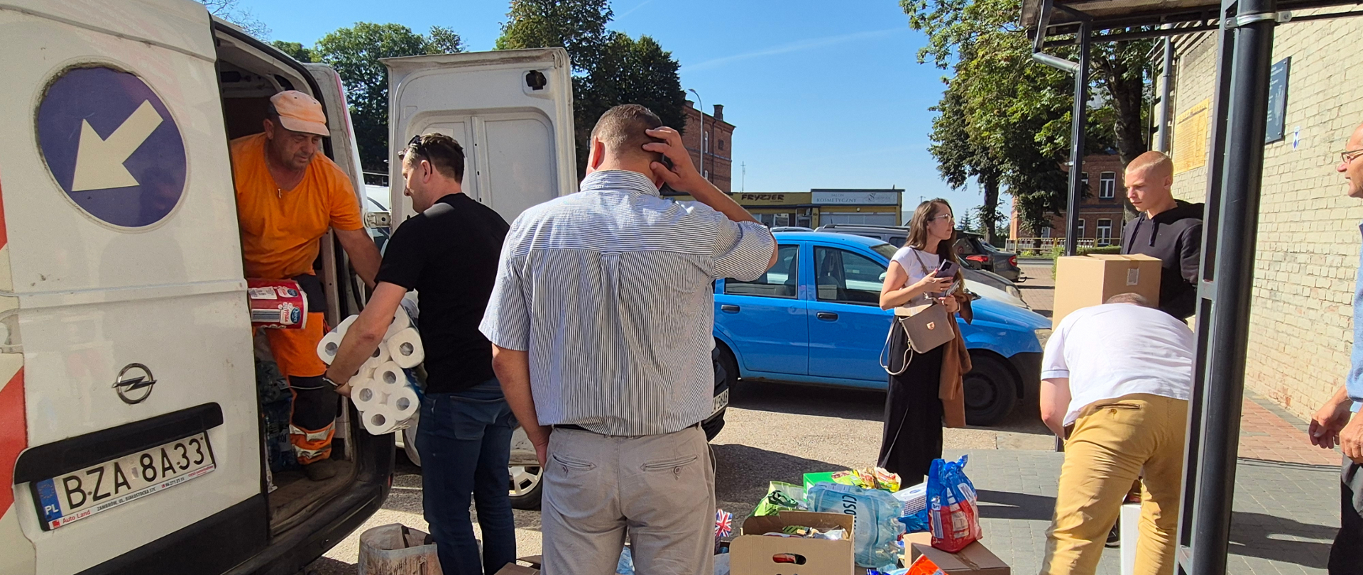 przy budynku ZSA w Zambrowie, pracownicy starostwa, wicedyrektor szkoły i wicestarosta pomagają w pakowaniu artykułów do samochodu starostwa