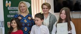 Zdobywcy pierwszych miejsc pozują z dyplomami i przedstawicielami Poradni